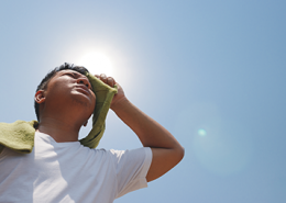 Child wiping forehead, hot in the sun