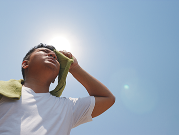 Child wiping forehead, hot in the sun