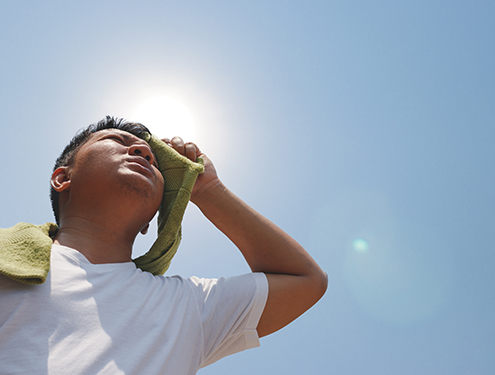 Person wiping forehead, hot in the sun