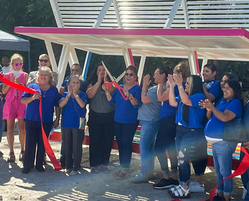 Collaborators celebrate the unveiling of a new bus shelter in Oasis, California