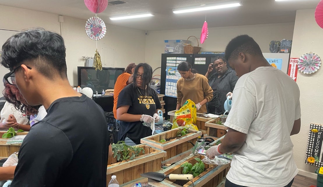 Christopher and Delilah plant herbs Christopher (second from right) and Delilah (right) table for Transform Fresno with other Youth Leadership Development Program participants.